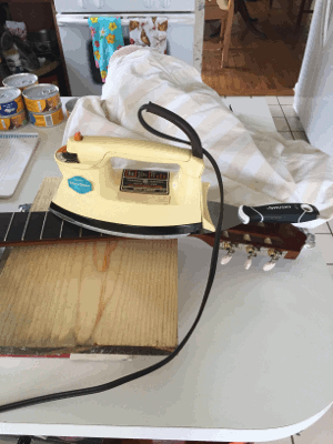 removing a classical guitar fretboard with an iron